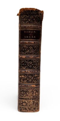 an old book that is sitting on a white surface