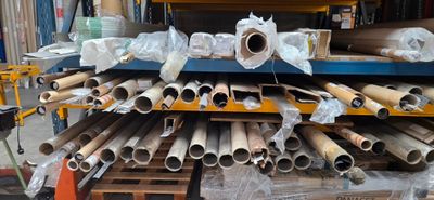 a large stack of pipes and tubes in a warehouse