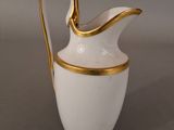 an image of a white and gold pitcher on a table
