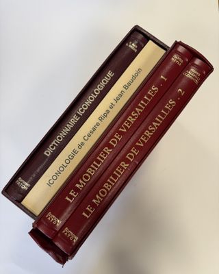 trois livres sont empilés sur une table