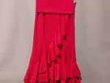 a red dress hanging on a hanger against a wall