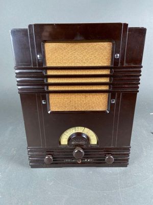 an old fashioned radio sitting on top of a table next to a clock