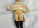 a doll that is laying down on a white sheet
