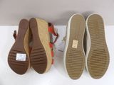 pair of women ' s shoes with red and tan soles on a white surface