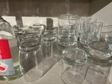 many glasses and a bottle of alcohol sitting on a counter