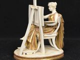 an image of a figurine of a woman sitting at a desk