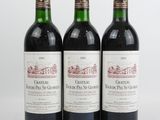trois bouteilles de vin rouge posées l'une à côté de l'autre sur une surface blanche