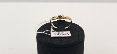 un gros plan d'une bague dans une boîte noire posée sur une surface blanche