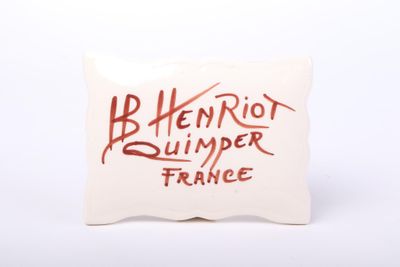 the pillow is white with red writing on it and has a red writing on it