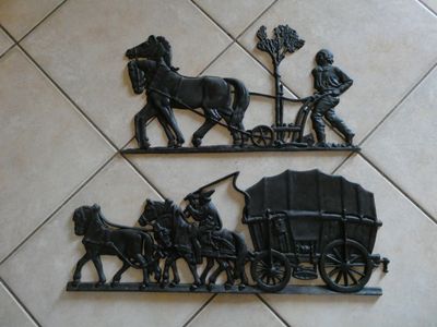 deux sculptures métalliques représentant des chevaux tirant un chariot et un homme dans une calèche