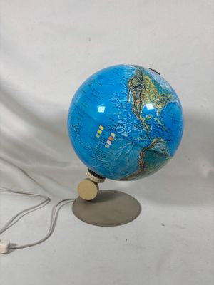 un globe bleu posé sur un socle, sur fond blanc