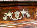 une commode en bois ornée de motifs en laiton sur le dessus