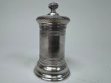 an antique silverplated salt shaker on a white background