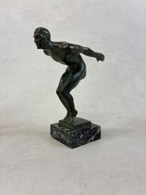 a statue of a man throwing a frisbee on a marble base