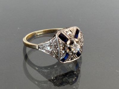 an image of a diamond and sapphire ring on a reflective surface