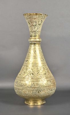 a gold vase sitting on a table with a gray background