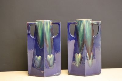 une paire de vases violets ornés de motifs verts et bleus