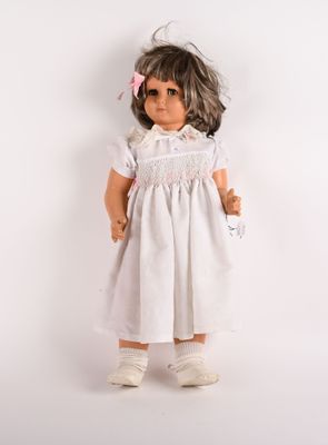une image représentant une poupée vêtue d'une robe blanche et de chaussures blanches