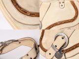 a white purse with a brown handle and a key on it