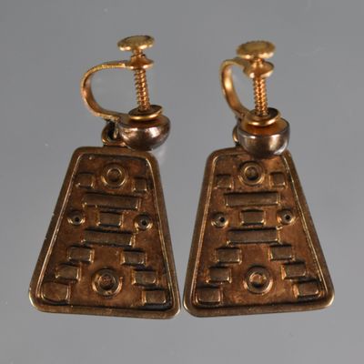 une paire de boucles d'oreilles de couleur dorée, munies de vis