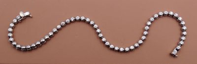 une image représentant un collier orné d'un serpent, posé sur une surface marron