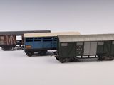 trois petits trains posés sur une surface blanche