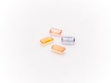 three different colored pills sitting on top of a white surface