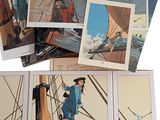 an assortment of books and postcards of a man on a boat