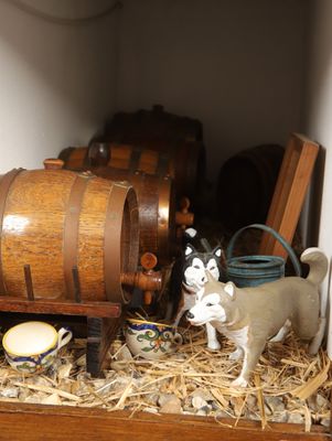 un petit tonneau en bois surmonté d'une figurine de vache