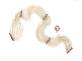 a close up of a necklace and a bracelet on a white surface