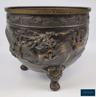 un grand bol en bronze orné d'un motif représentant un dragon