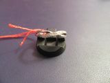 a red string tied to a black object on a table