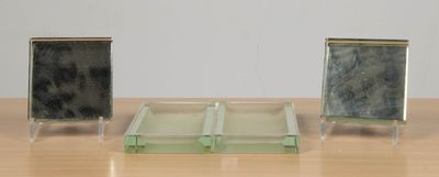 trois petites boîtes en verre posées sur une table en bois