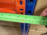 a person holding a measuring tape in front of a shelf