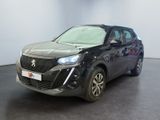La voiture noire est garée dans une grande pièce au sol noir.