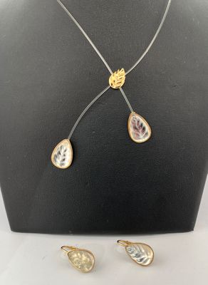 LALIQUE. Parure en métal doré, fil de plastique et cabochons…