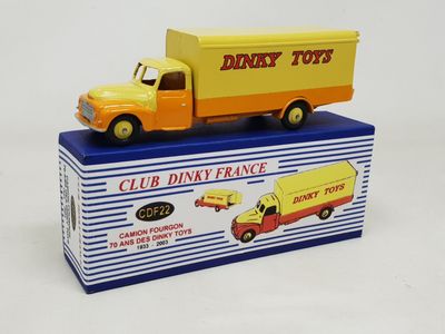 yellow and orange toy truck sitting on top of a blue and white box