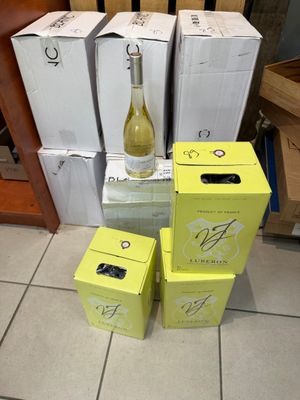 Plusieurs cartons de vin sont empilés les uns sur les autres par terre