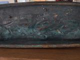 an old metal tray sitting on top of a wooden table