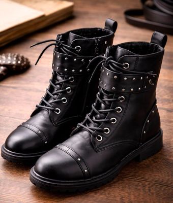 une paire de bottes en cuir noir posée sur une table en bois
