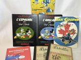 plusieurs livres sont empilés sur une surface blanche
