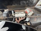 an old car engine with a lot of old batteries in it