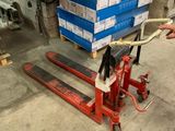 a man standing next to a pallet with a dog on it