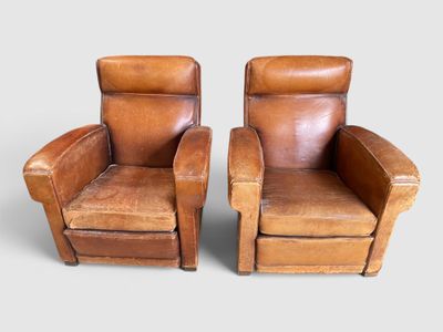 deux fauteuils inclinables en cuir marron placés côte à côte sur une surface grise