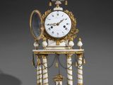 a white and gold clock with a mirror on top of it