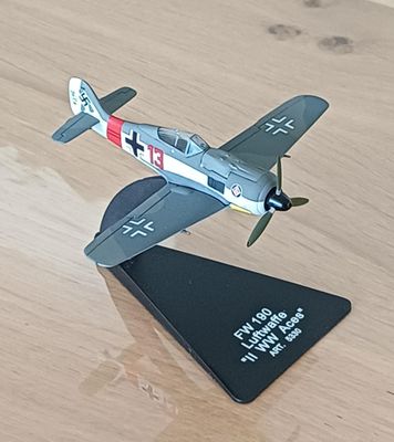 une petite maquette d'avion posée sur une table en bois
