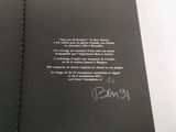 an open book with a picture of a person holding a pen and writing on it