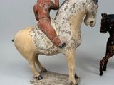 two figurines of a man riding a horse and a dog