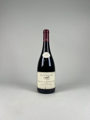 la bouteille de vin rouge est posée sur une surface blanche