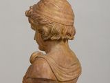 a statue of a woman with a hat on top of a table